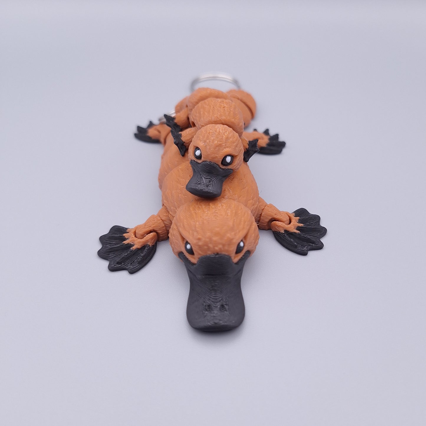 Realistic articulated platypus fidget toy with wide bill and sculpted limbs and platypus keychain
